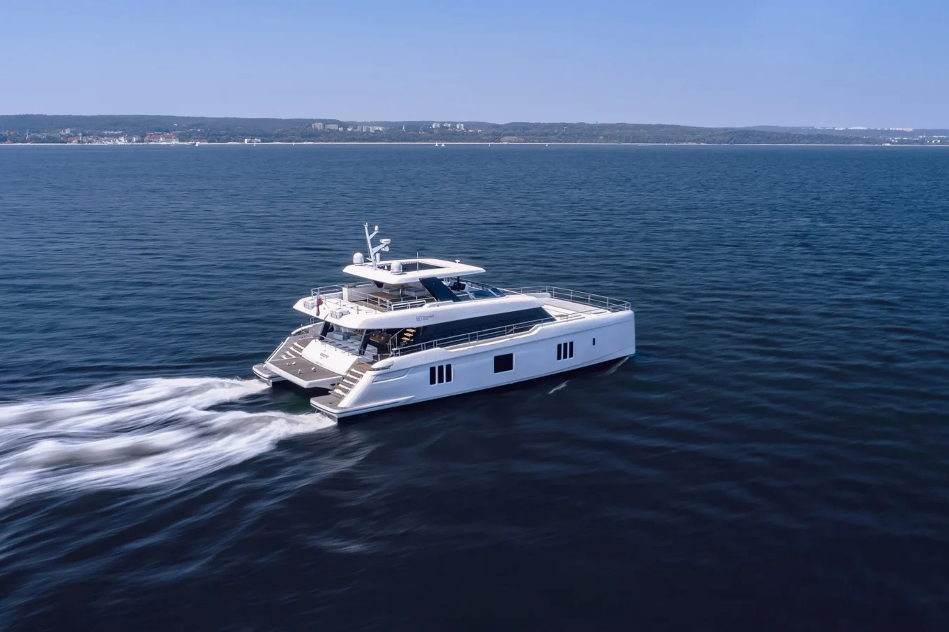 Sunreef Yachts 80 Kokomo cruising smoothly across sparkling blue waters under a clear sky.