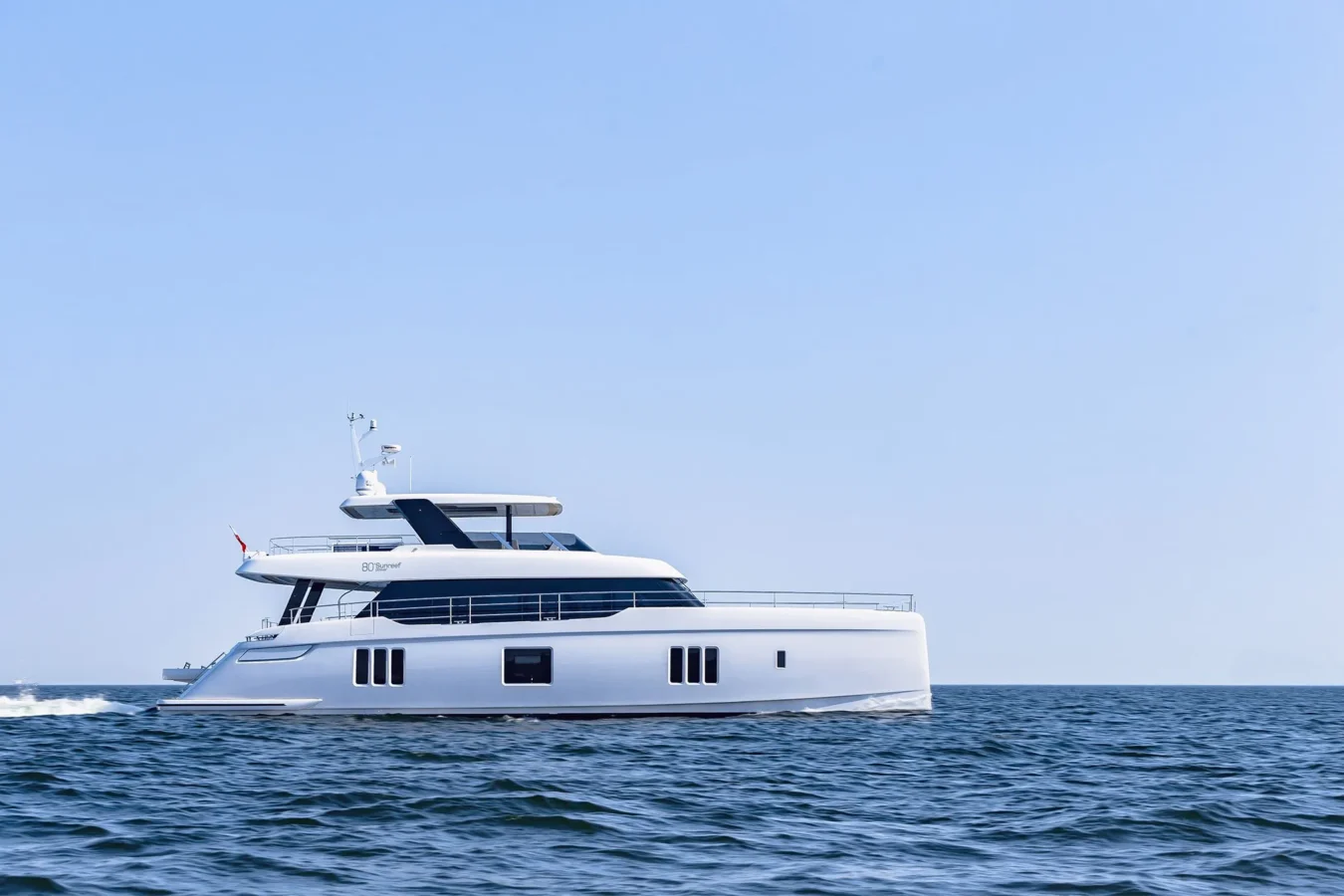 Sunreef Yachts 80 Kokomo cruising smoothly across sparkling blue waters under a clear sky.