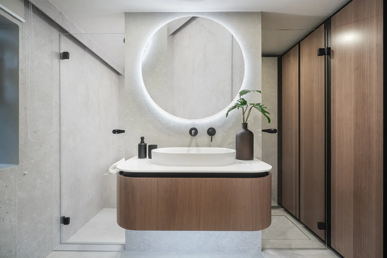 Round illuminated mirror and elegant washbasin in the bathroom of Sunreef Yachts 80 Kokomo.