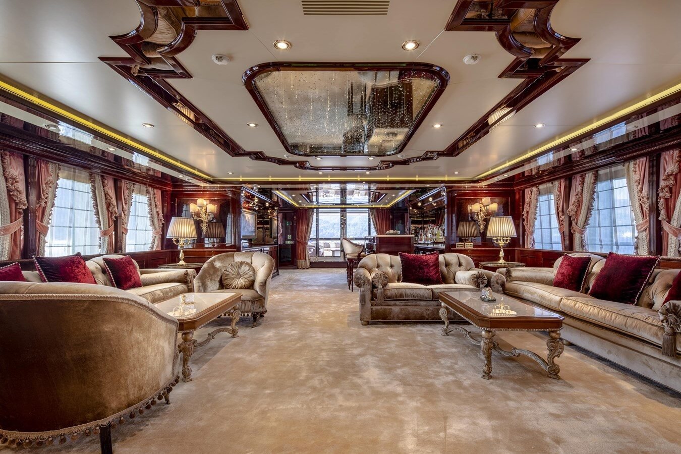 Opulent salon aboard CRN 186 “Richard” with red and gold luxury décor and plush furnishings.