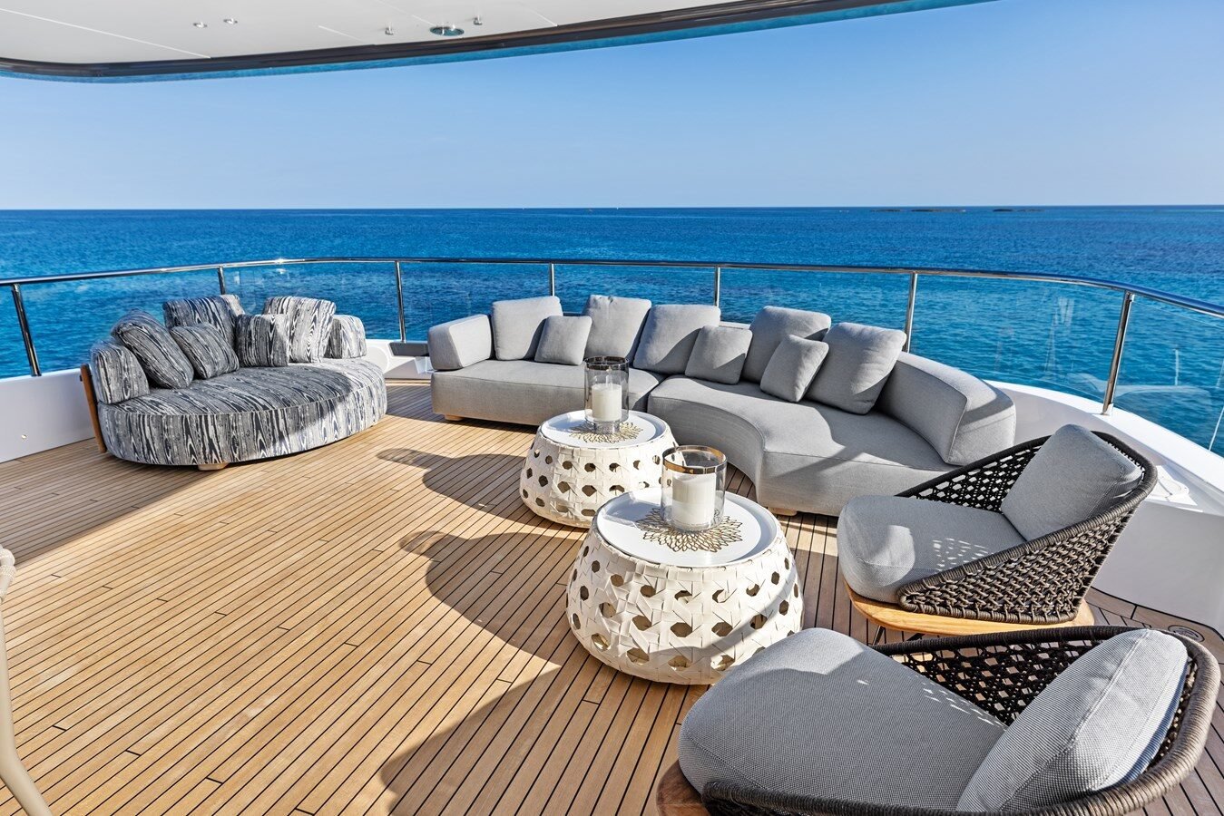 Aft seating area aboard Benetti 133 “Contigo” with cushioned sofas, teak decking, and ocean views.