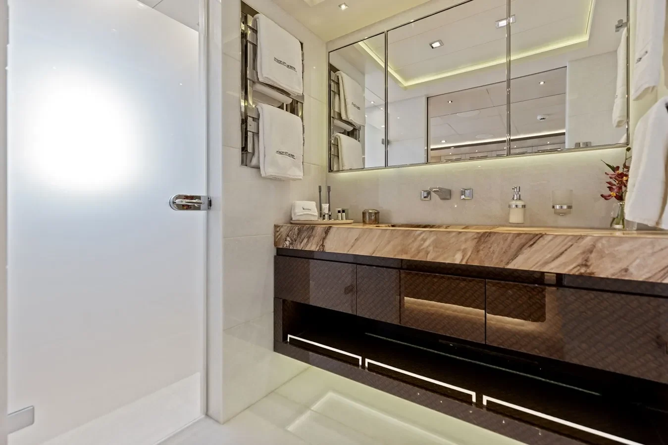 Elegant yacht bathroom with marble finishes, glass shower, and premium fixtures.