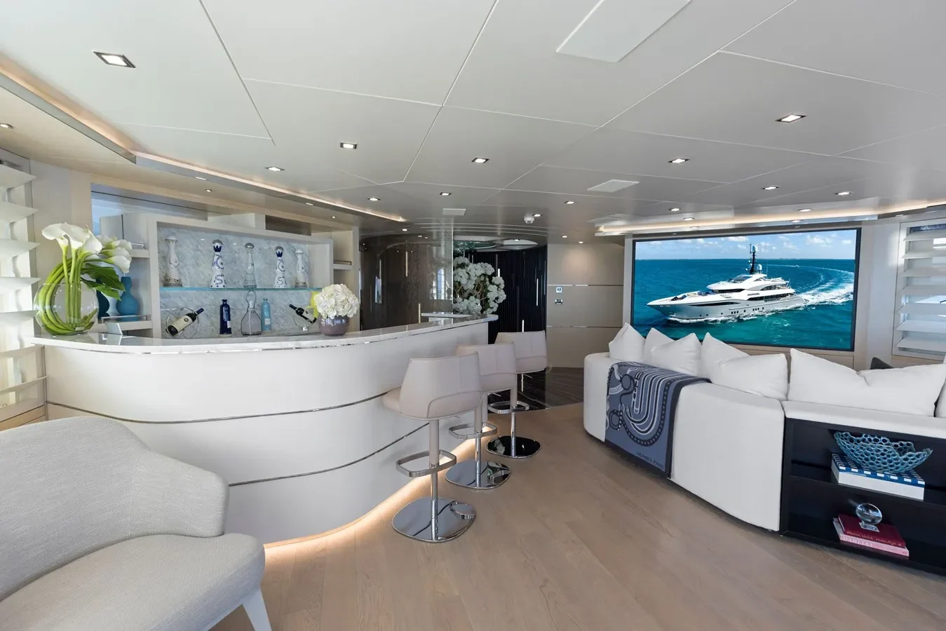 Stylish yacht interior bar with lounge seating and large flat-screen TV.