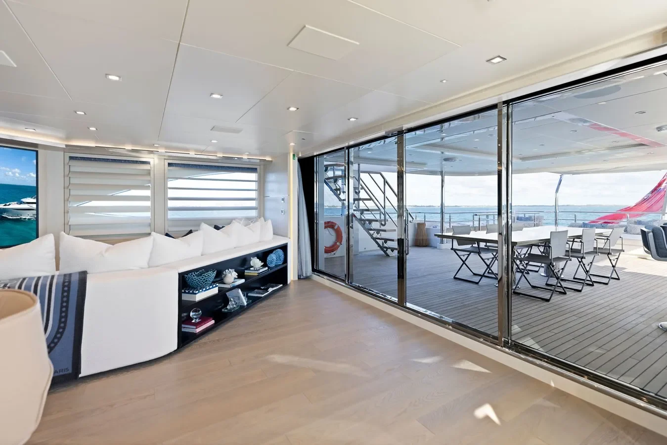 Stylish yacht lounge seamlessly connected to the aft dining area with transparent sliding doors.