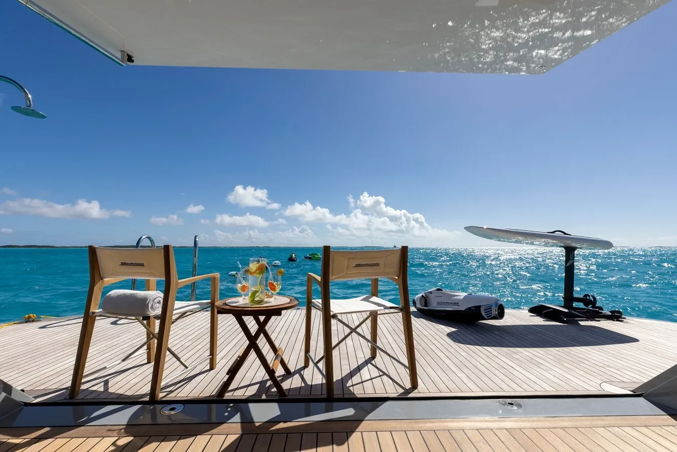Spacious yacht beach club with lounge chairs and water toys by the sea.