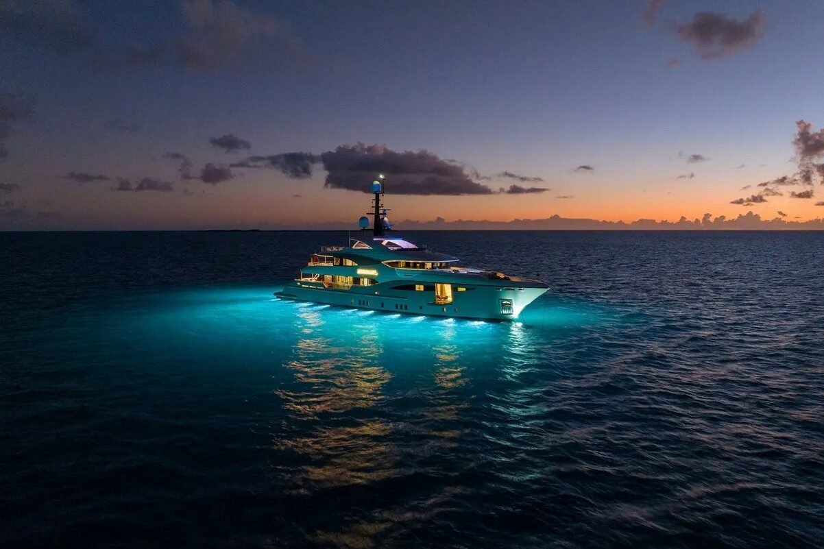 Exterior night view of Bilgin Yachts 156 Moonraker with glowing lights and unfolded side platform.