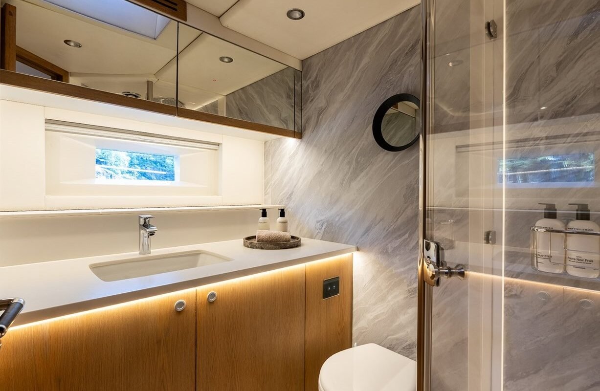 Luxury yacht bathroom with vanity and glass shower aboard Oyster Yachts 86 Champagne Hippy