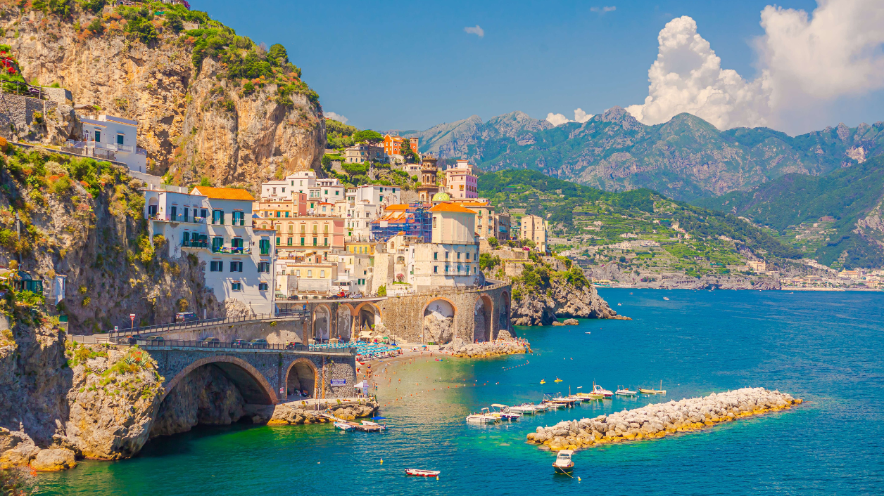 Colorful cliffside buildings overlook the turquoise sea of Italy's Amalfi Coast, perfect for travel and adventure.