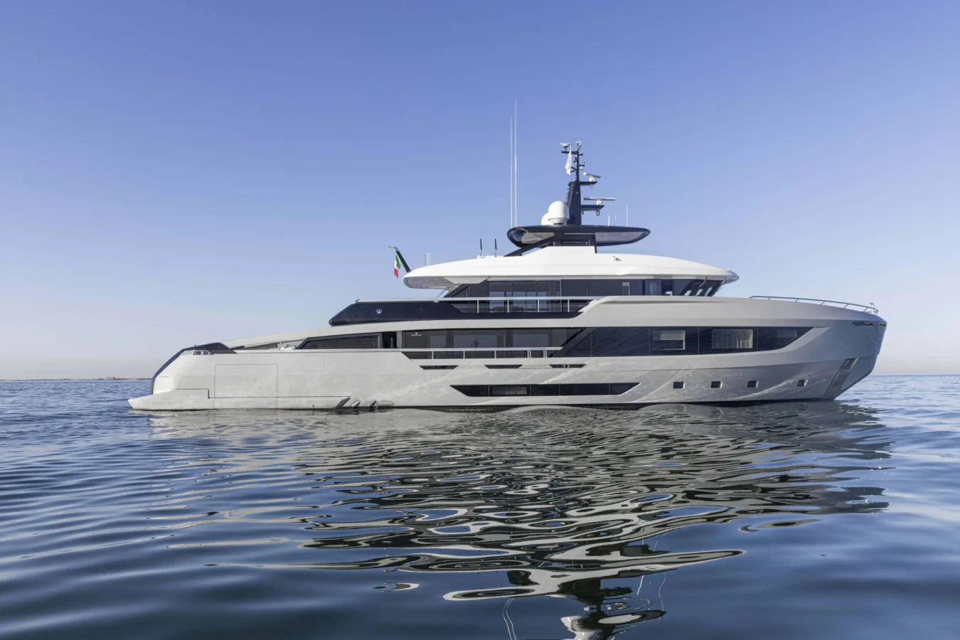 Side profile of the Ocean King DOGE 400 explorer yacht cruising on calm water, showcasing its steel hull and modern superstructure.