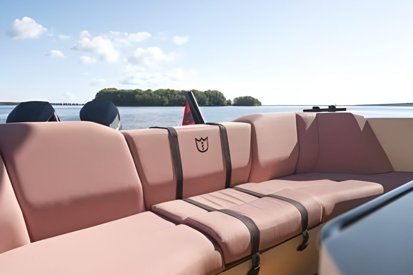 Cockpit seating area of the LEKKER 38 yacht with upholstered bench, teak decking, and open sea views