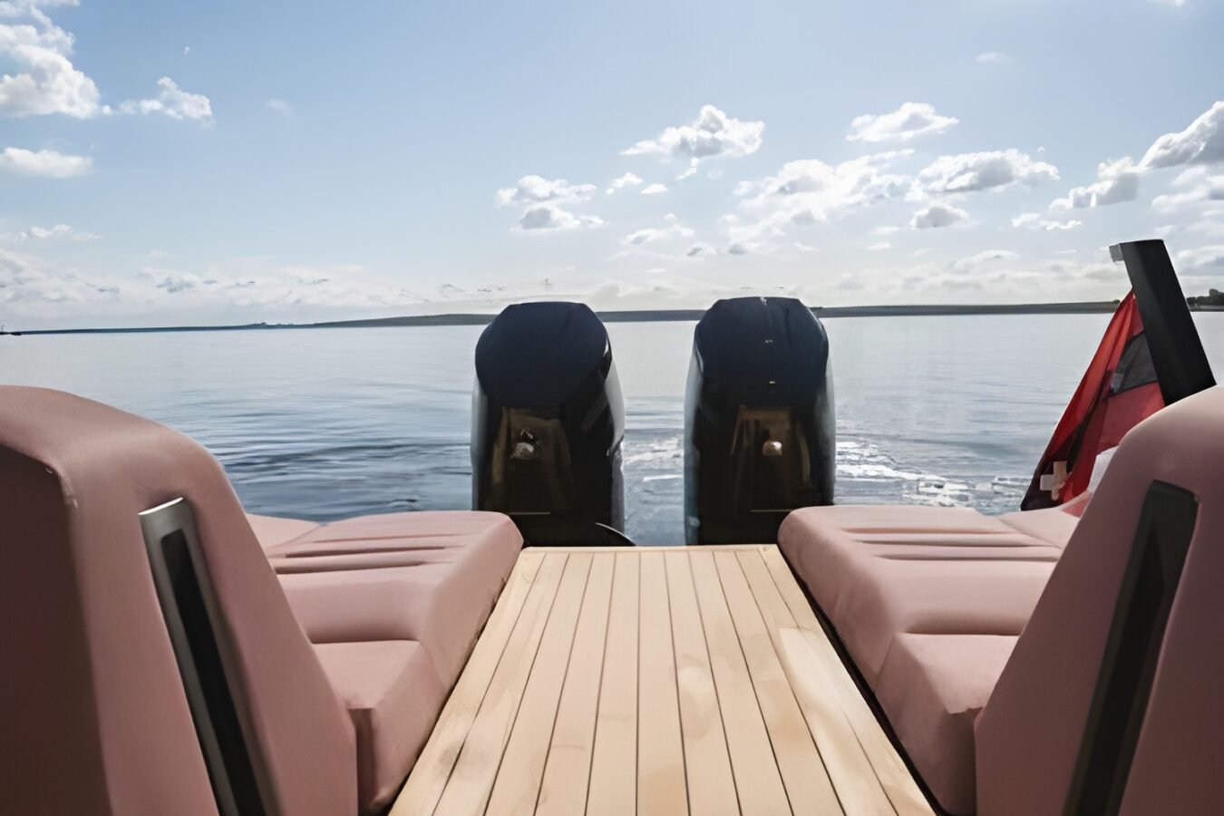 Aft deck of the LEKKER 38 yacht showing teak walk-through, sun pads, and twin outboard engines at rest