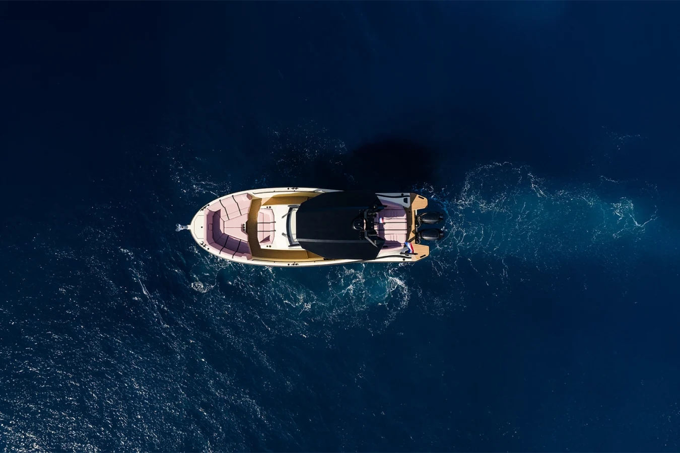 Top-down aerial view of the LEKKER 38 yacht cruising through deep blue open water