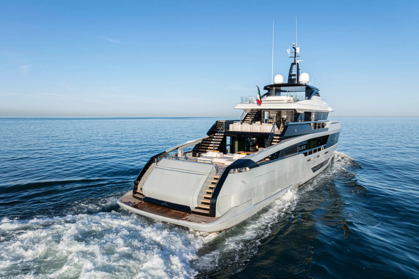 Aft view of the Ocean King DOGE 400 explorer yacht cruising on open water, showcasing the stern steps and upper decks.