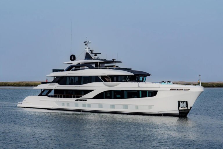 A Majesty 145 superyacht cruises on calm water, featuring a modern white multi-deck design with tinted windows.