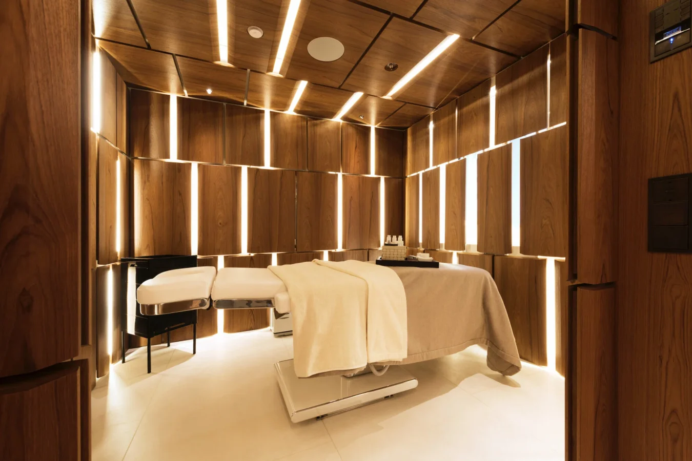 Modern spa room with massage table, soft lighting—like the serenity on the Abeking Rasmussen Cloudbreak yacht for charter.