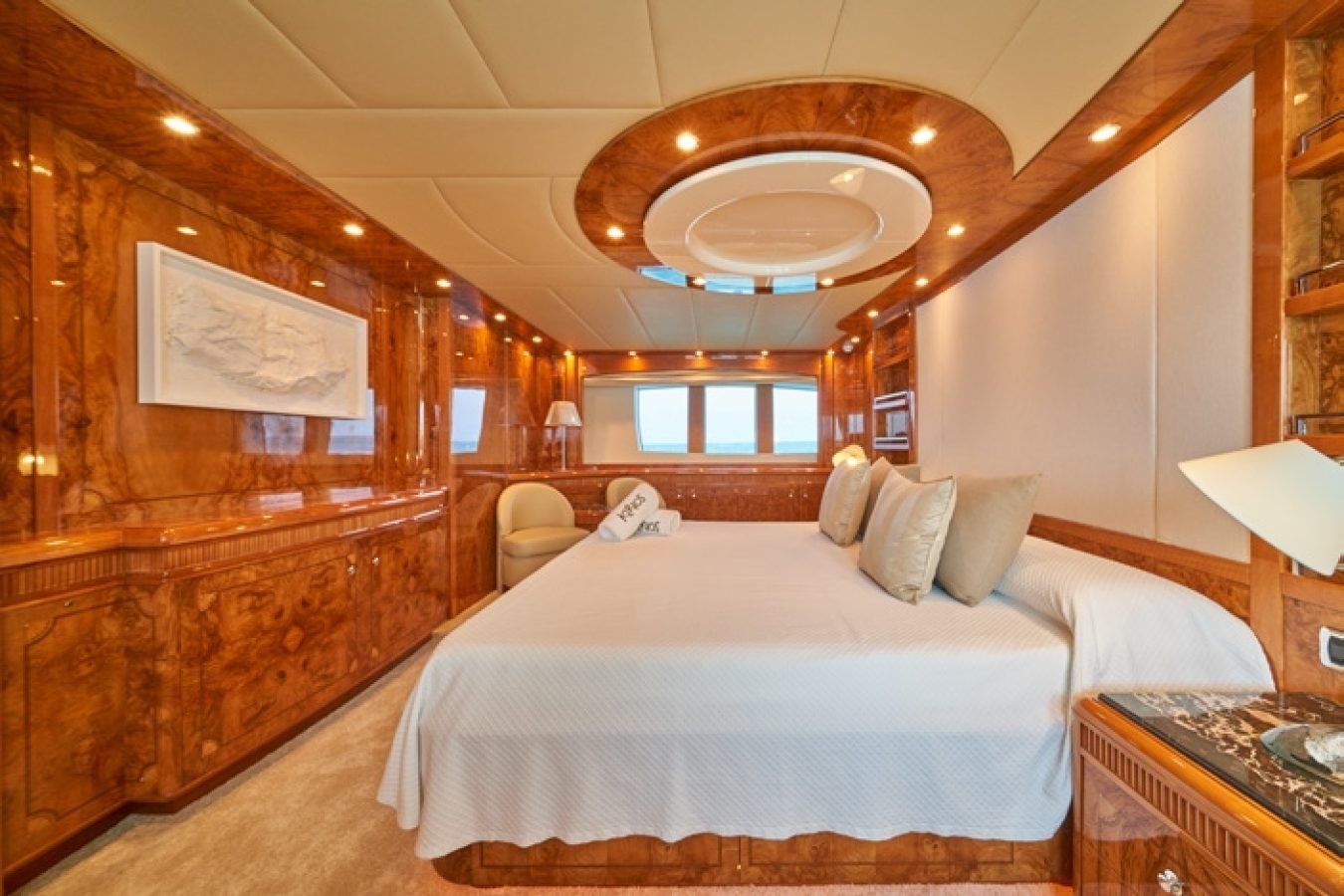 Luxurious Astondoa 102 GLX My Kirios Yacht For Charter bedroom with wood paneling, large bed, windows, and modern decor.