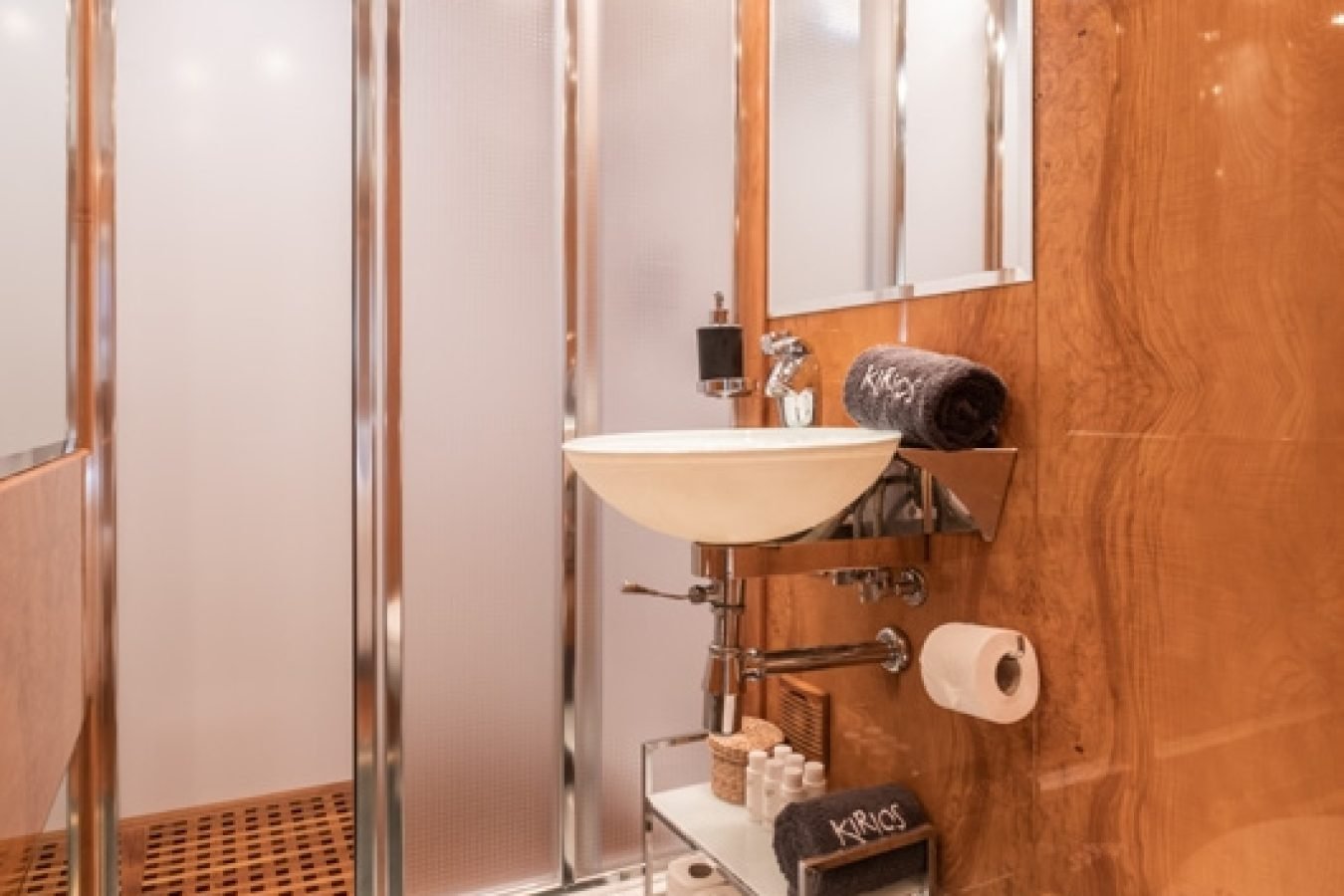 Elegant bathroom aboard Astondoa 102 GLX My Kirios Yacht, with wood walls, marble floor, modern sink, and glass shower.