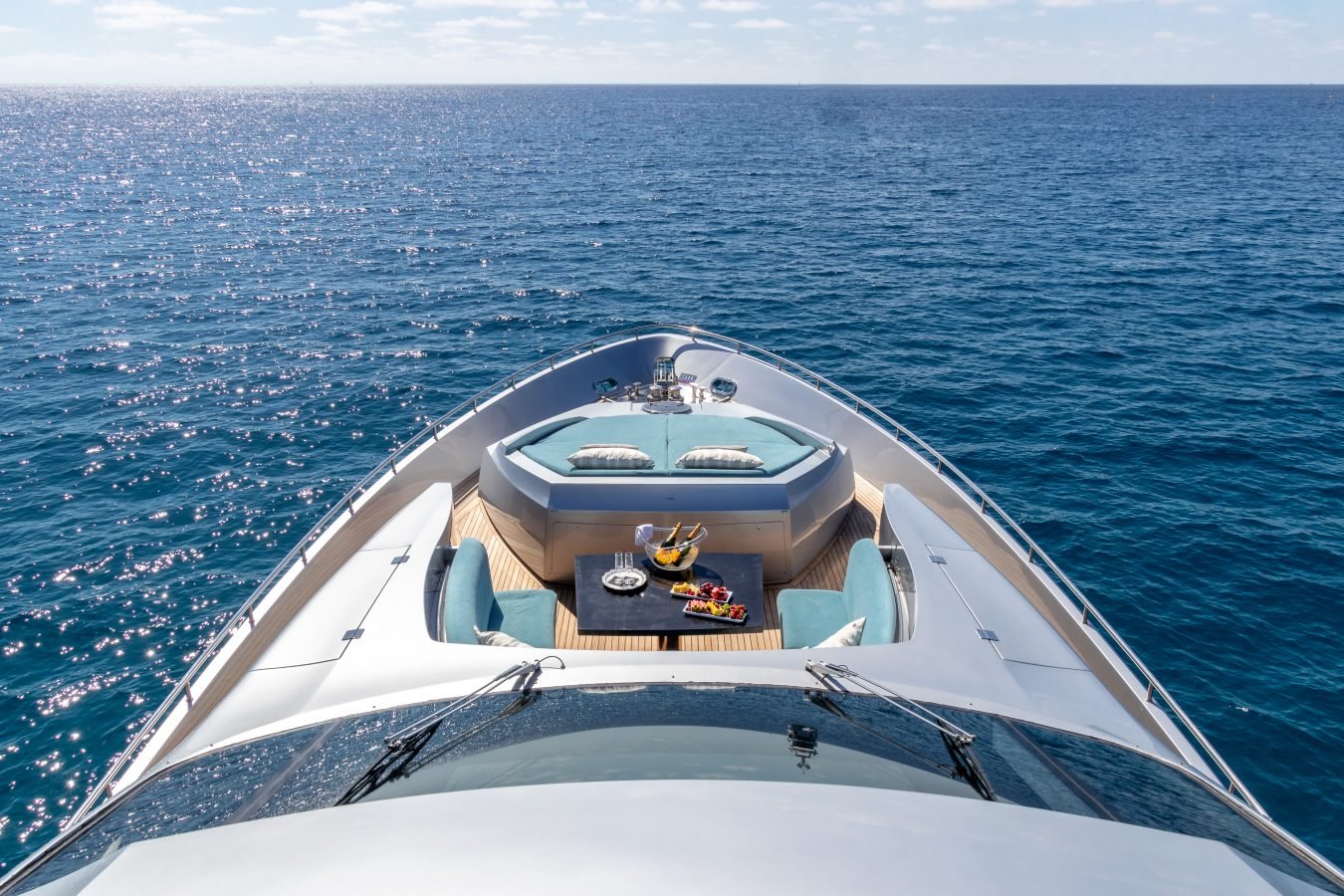 Experience the Pershing 90 Inspiration Yacht for Charter: luxury sunbeds, fine dining, and endless blue ocean views.