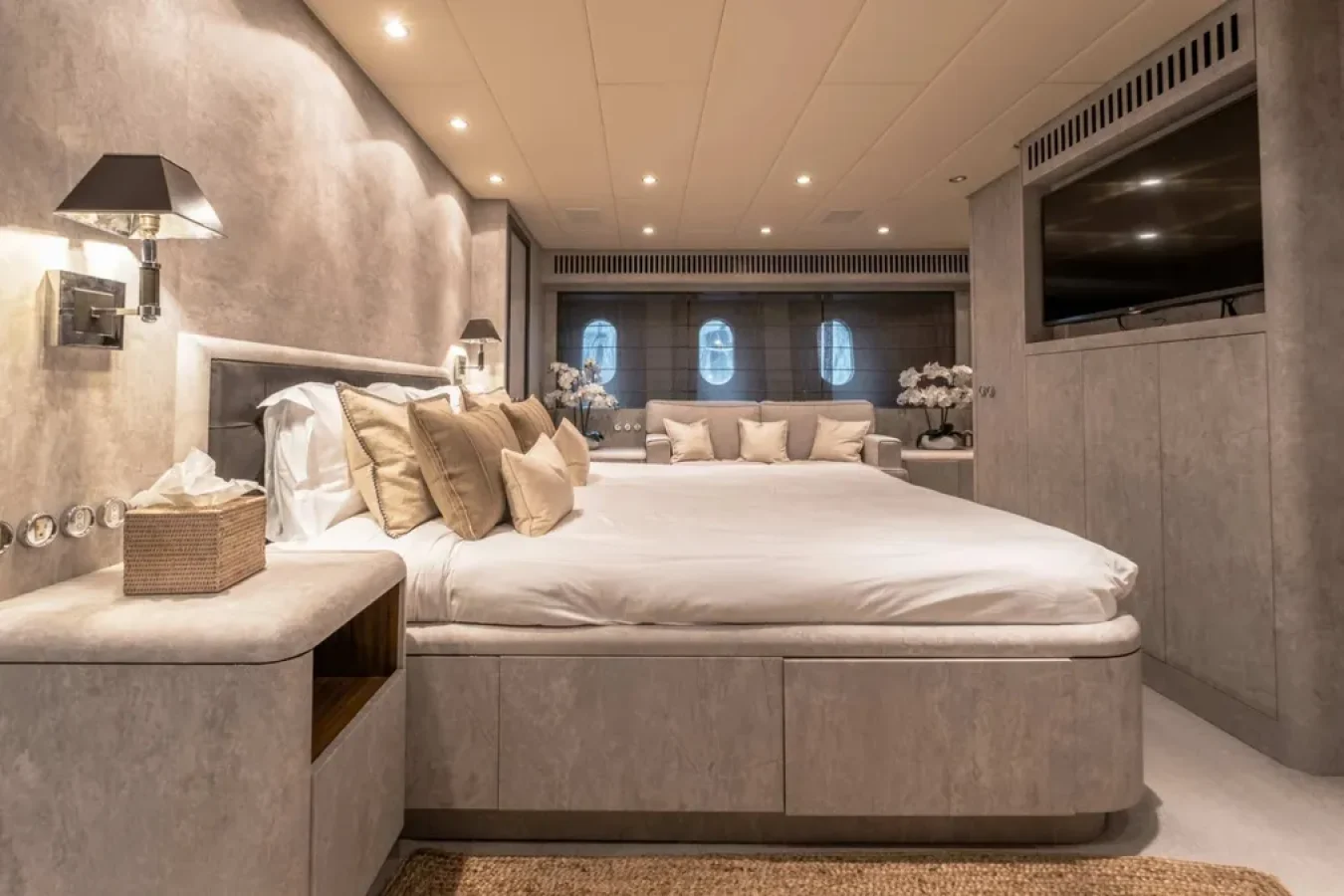 Modern bedroom on DARK KNIGHT Yacht with large bed, neutral tones, porthole windows—luxury yacht for charter.