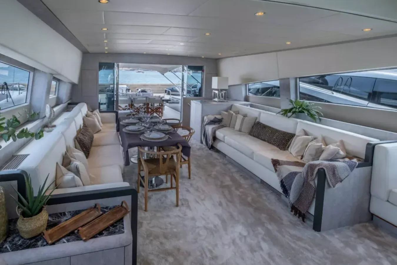 Luxurious LEOPARD 102 DARK KNIGHT Yacht lounge with elegant sofas, set dining, large windows, and chic decor accents.