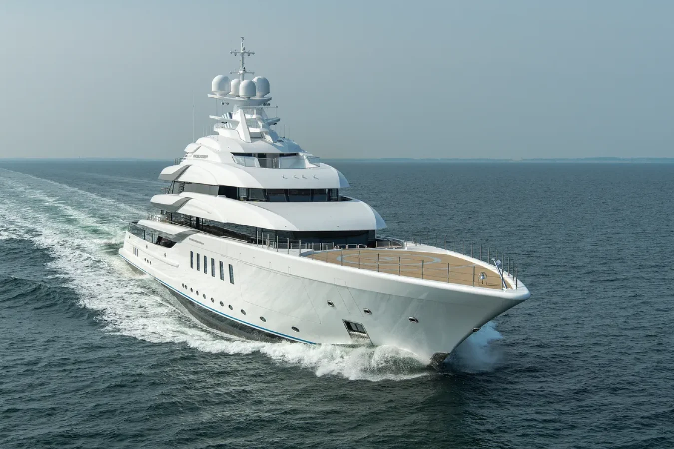 Lurssen CC-Summer Yacht for Charter cruising on calm blue ocean, leaving a wake behind under a clear sky.