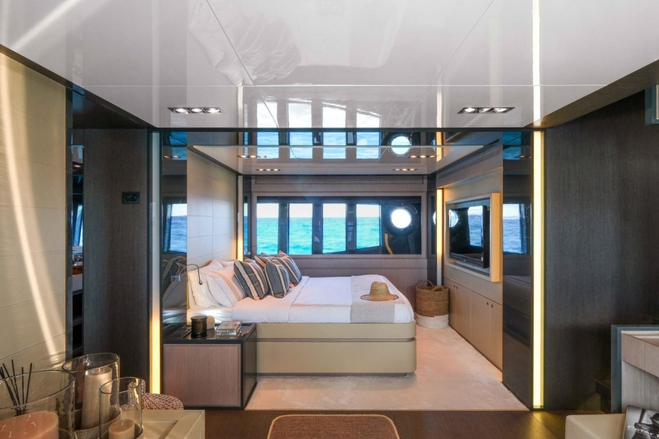 Modern Riva 86 Tanit yacht bedroom with large windows, neutral tones, double bed, and ocean views—perfect for charter.