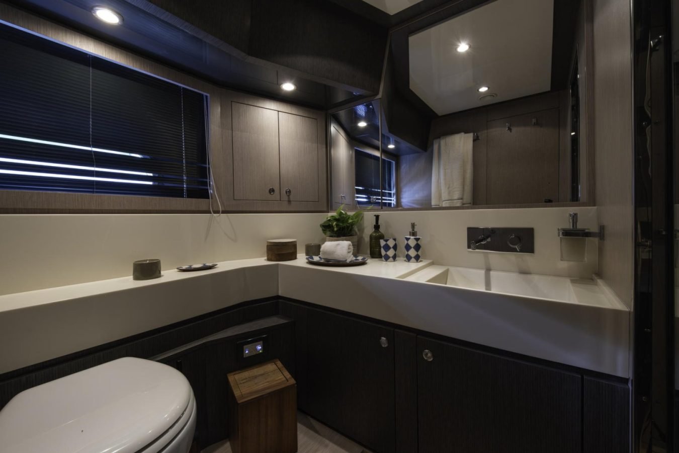 Modern bathroom with dark cabinets, a white sink, and sleek decor—perfect for the Riva 86 Tanit yacht charter experience.