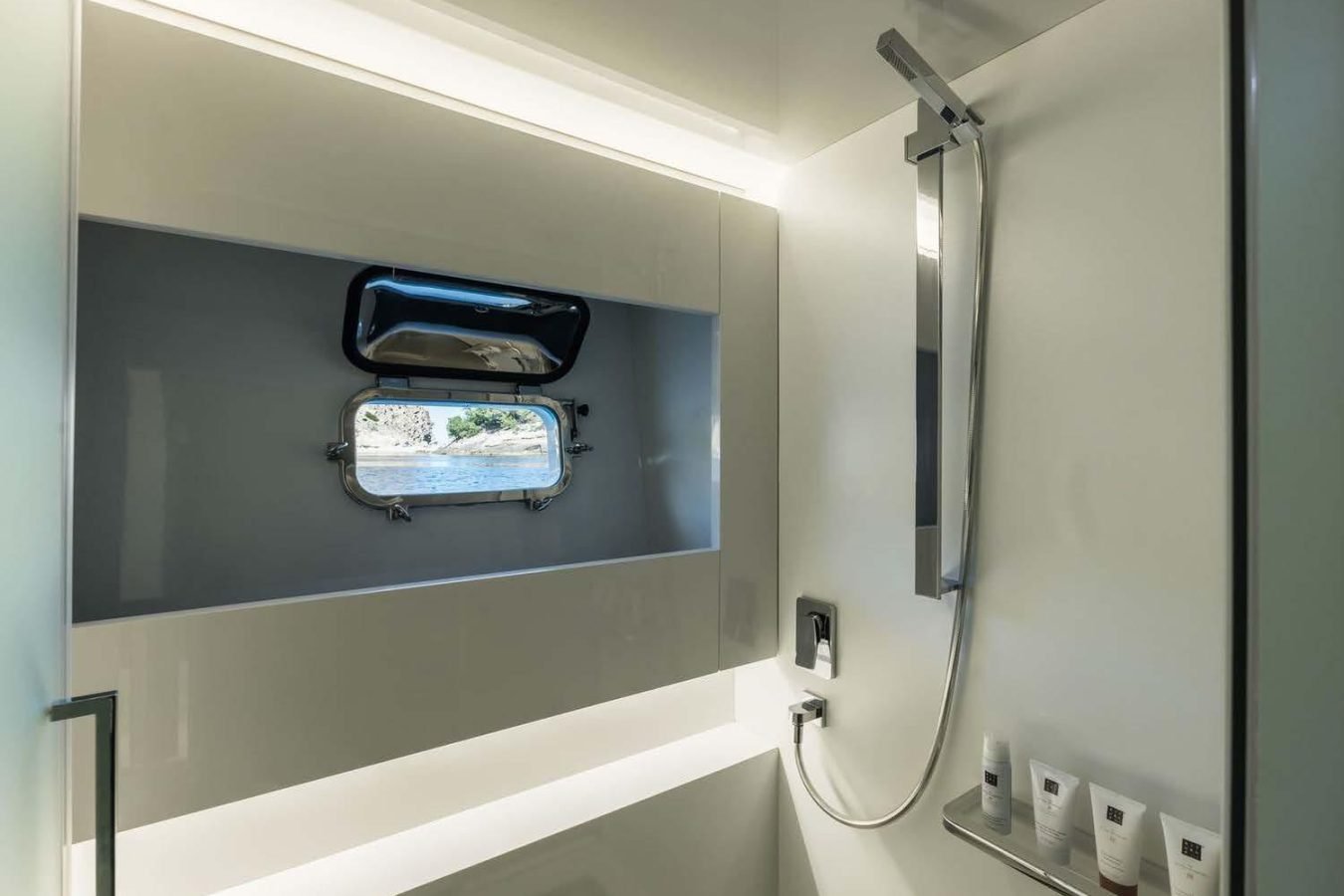 Modern Arcadia 85 yacht bathroom with window, shower, and toiletries; sunlight streams in—perfect for your charter.