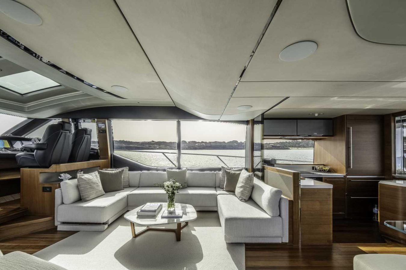 This Why Knot Yacht interior features modern sofas, wood floors, large windows, and a sleek kitchen with water views.