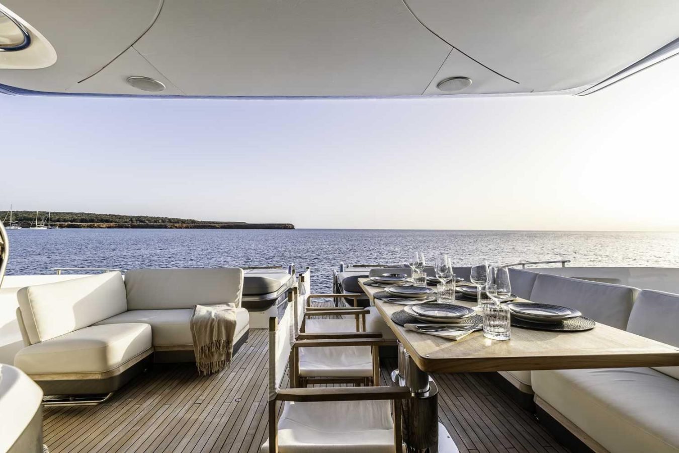 Experience sunset dining on the Why Knot Yacht Princess S78—luxury deck, ocean views, and white sofas await.